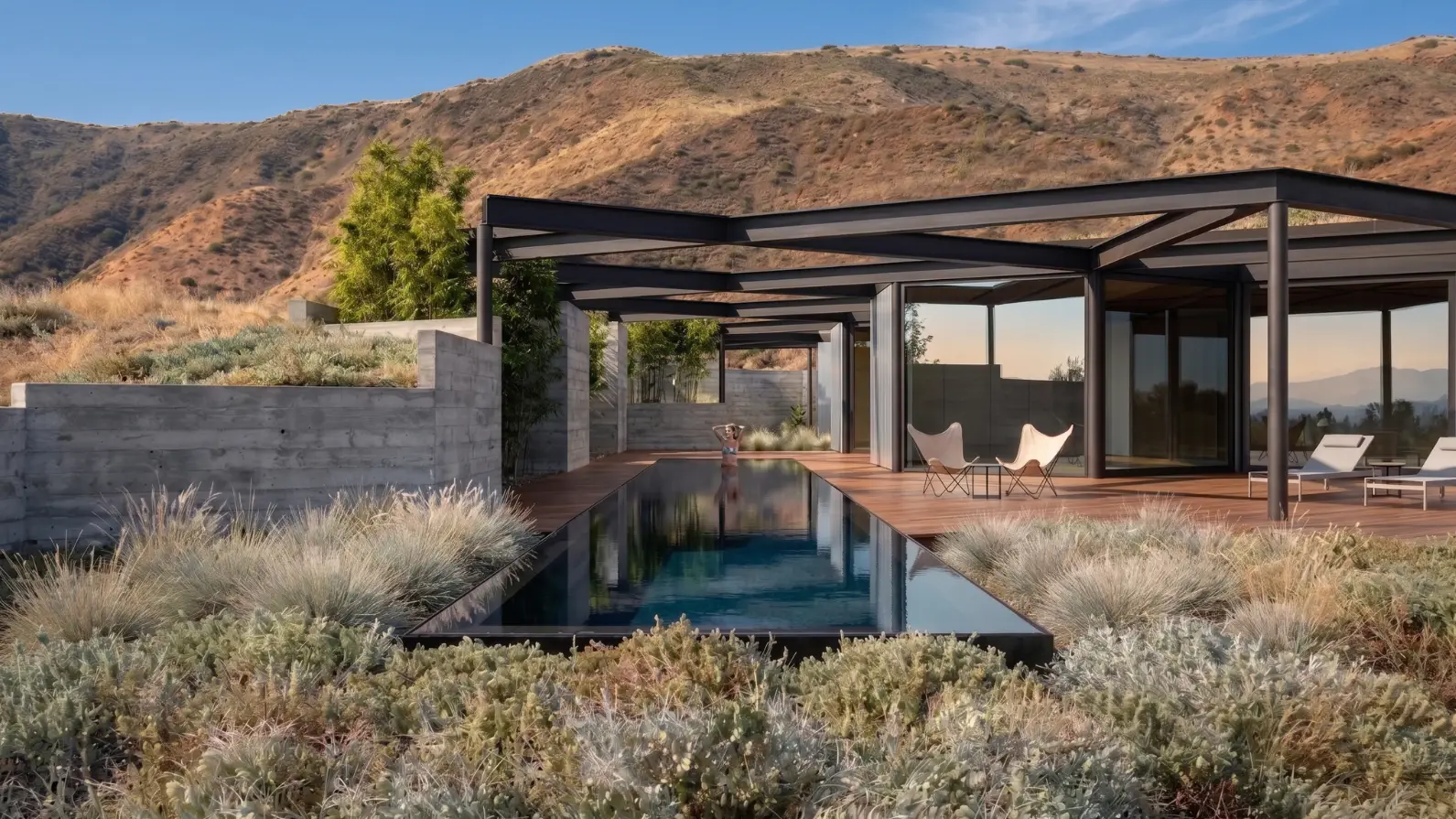 Rendering of a house with a steel pergola, board-formed concrete walls and a black infinity pool at dusk, on a hillside